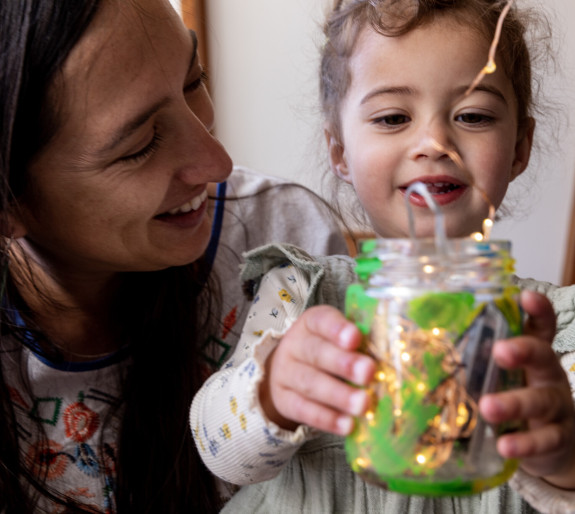 Mum and child holdiing jar of fairy lights