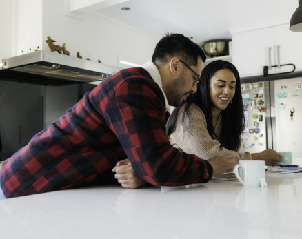 Couple leaning on kitchen bench