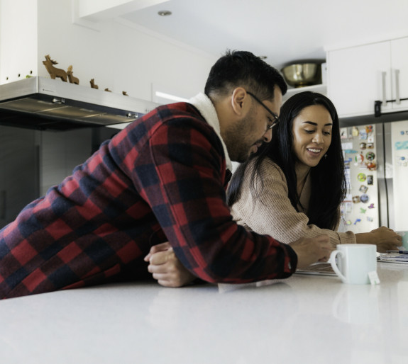 Couple leaning on kitchen bench