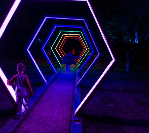 Children running through a light tunnel